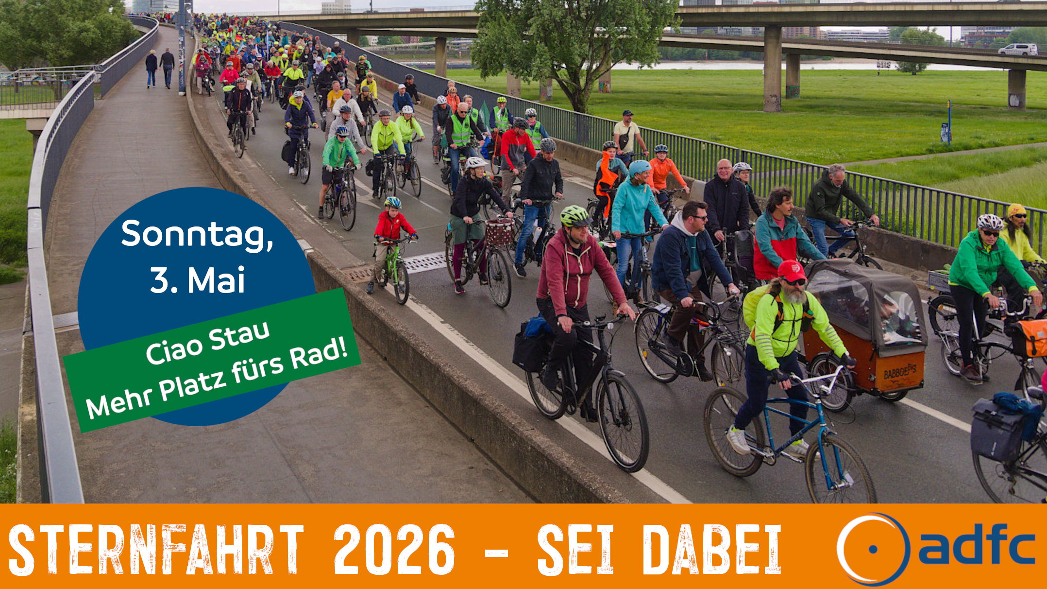 Das Bild zeigt eine große Gruppe Radfahrende, welche die Rampe der Oberkasselerbrücke herunterfahren.