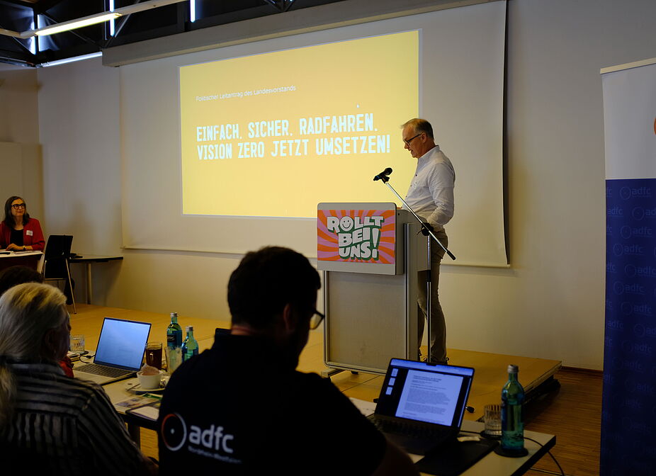 Landesvorstandsmitlglied Marc Zietan stellt den politischen Leitantrag vor Landesvorstandsmitlglied Marc Zietan stellt den politischen Leitantrag auf der Landesversammlung 2026 am 18. April 2026 in Münster vor.