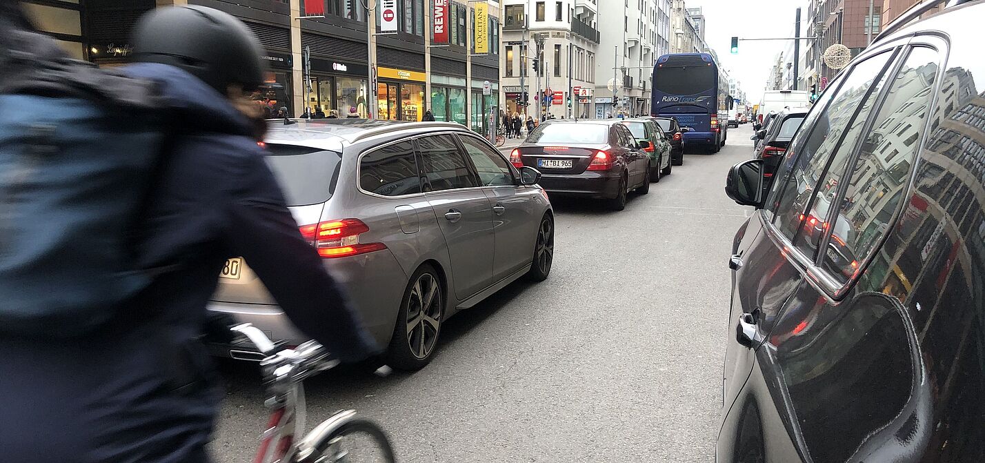 Radfahrer zwischen Autos ohne eigenen Radweg